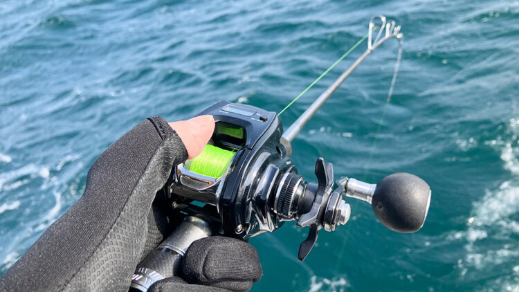 筆者が実釣でベイトリールをつけているところ